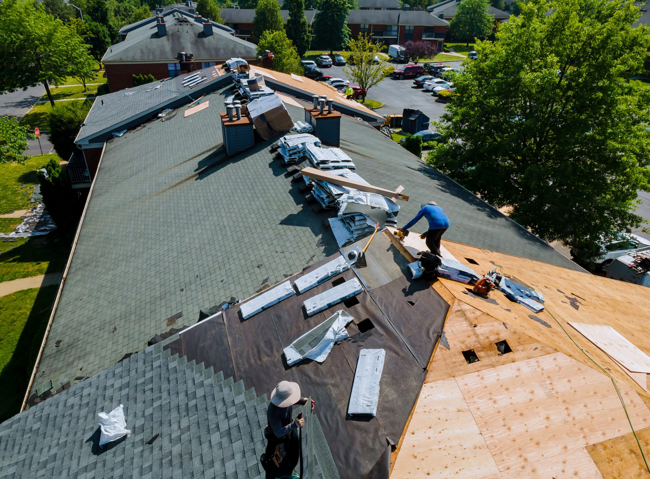 Workers installing asphalt shingles on a new roof in Connecticut